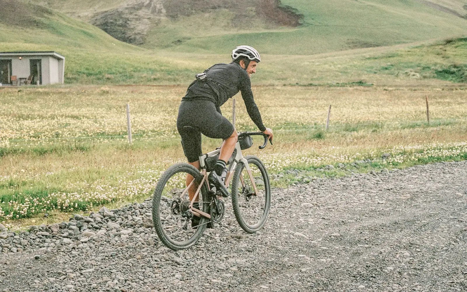 Cyclist on a drop-bar gravel bike riding an unpaved gravel road